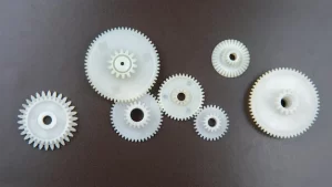 white-plastic-gears-dark-background-connection-mechanism-details-subject-movement_158518-16378